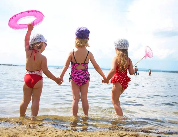 3 kinderen in badpak met voetjes in het water van het veerse meer