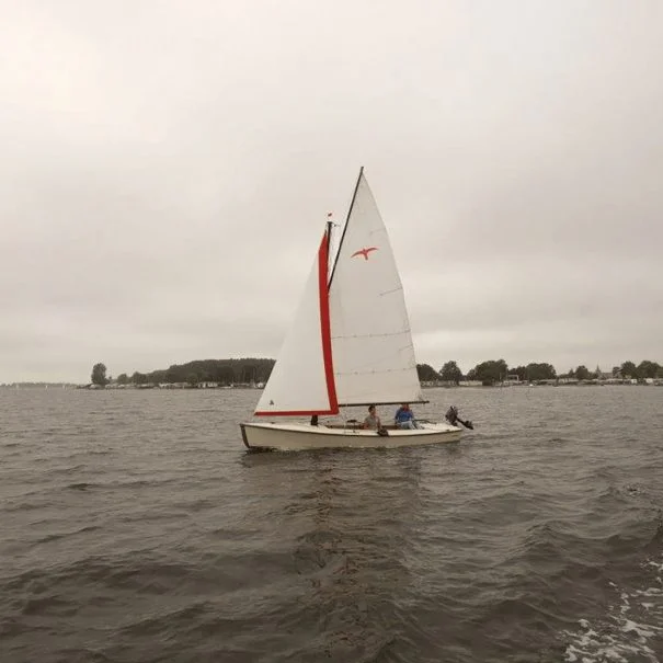 Een witte Valk huur zeilboot met 2 personen zeilend op het Veerse Meer bij Kortgene